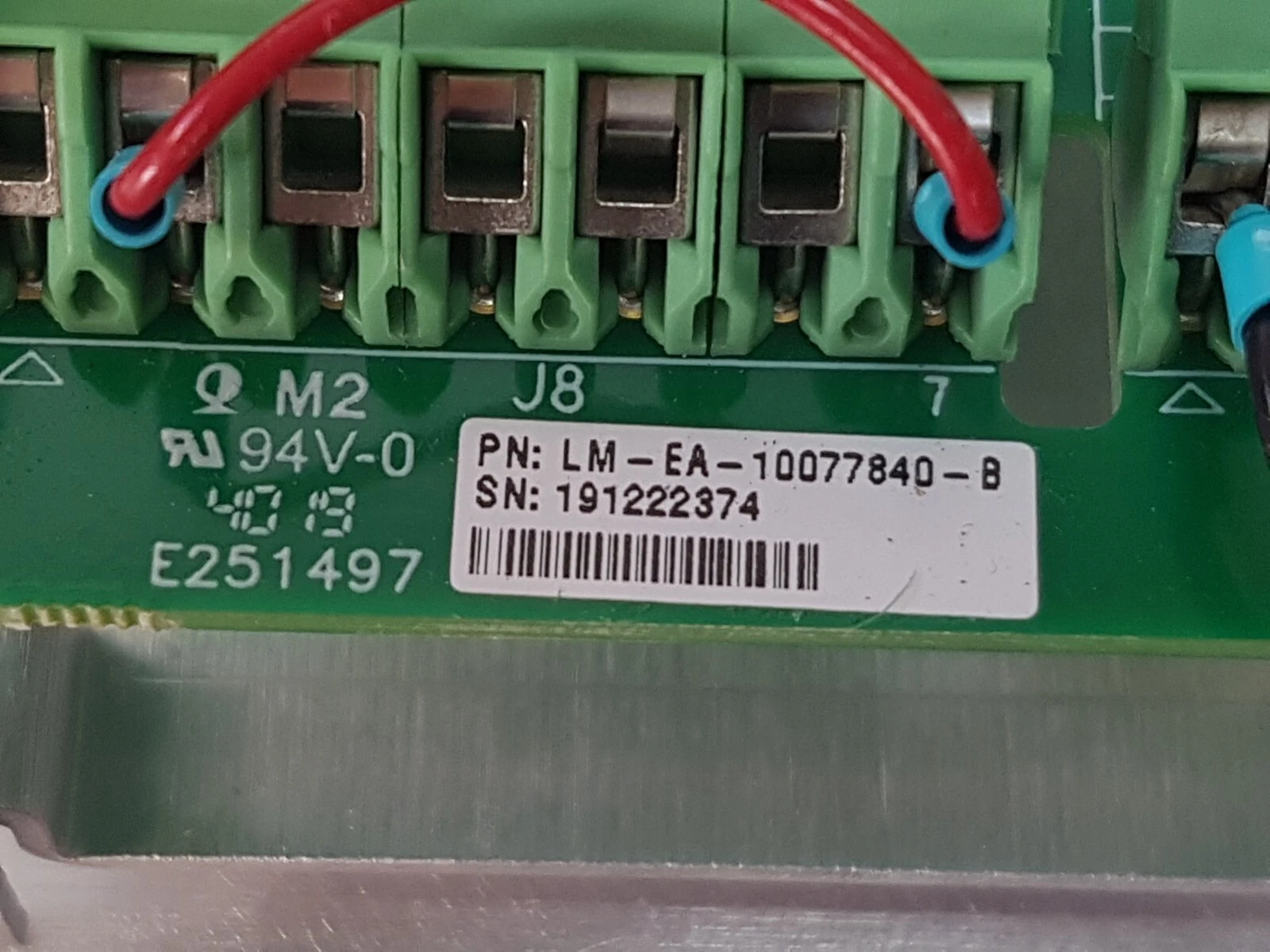 Close-up of the LM-EA-10077840-B part-number label next to terminal block J8