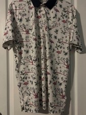 Puma Golf polo shirt in the "Lagoon" print featuring a white base with flamingo