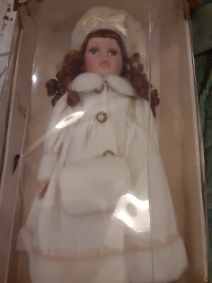 Porcelain Doll by Collectors Choice, she has reddish hair with a white coat 