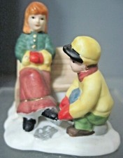 CERAMIC SNOW VILLAGE FIGURE BOY HELPING GIRL PUT ON ICESKATES