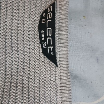 grey jumperwith slits in arms.