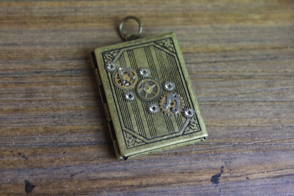 A gold-tone locket that opens like a tiny puzzle box AND reads like a miniature book — 11.9g of antique wearable intrigue.