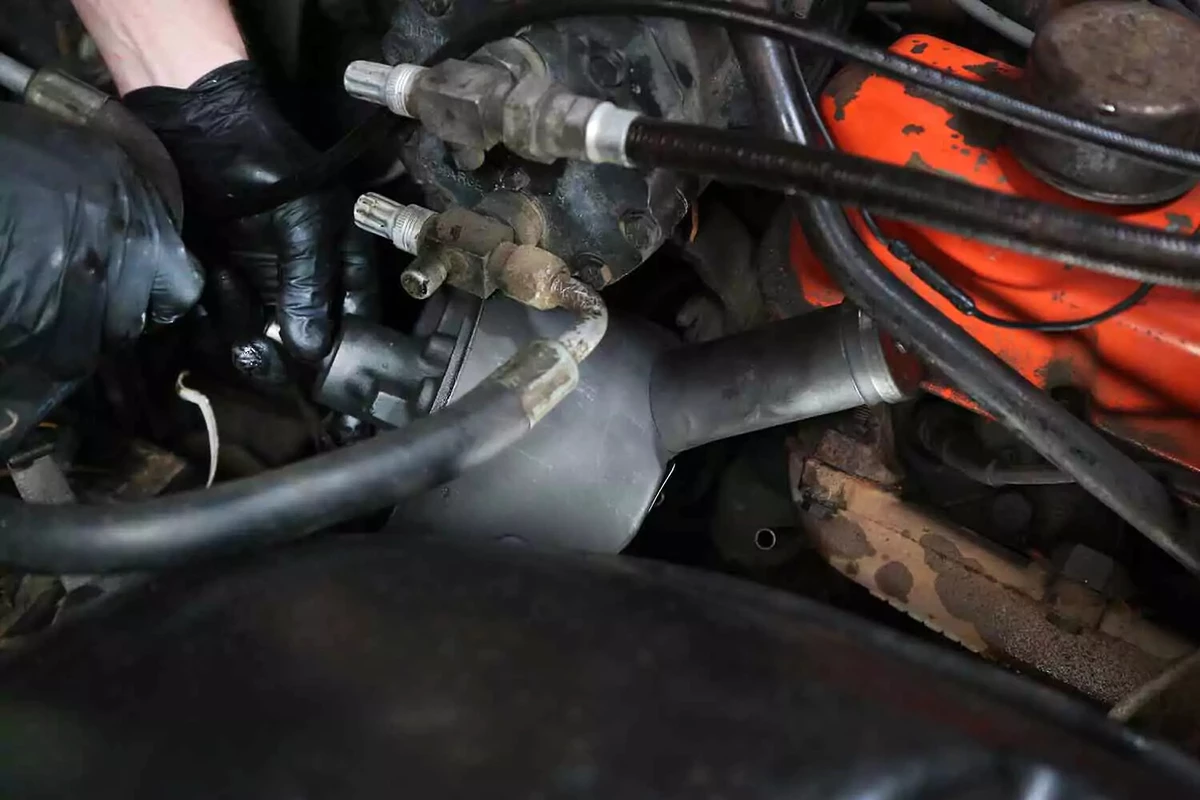 A mechanic maneuvers the new power steering pump into its mounting location on the engine.