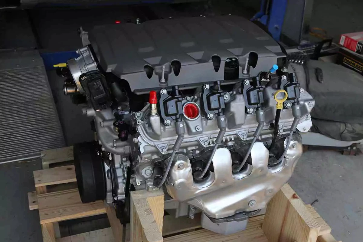 A modern V-8 engine with individual coils on each spark plug, resting on a wooden crate.