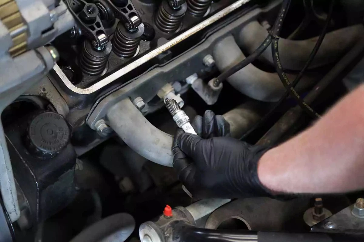 A mechanic removes the spark plug from the first cylinder.