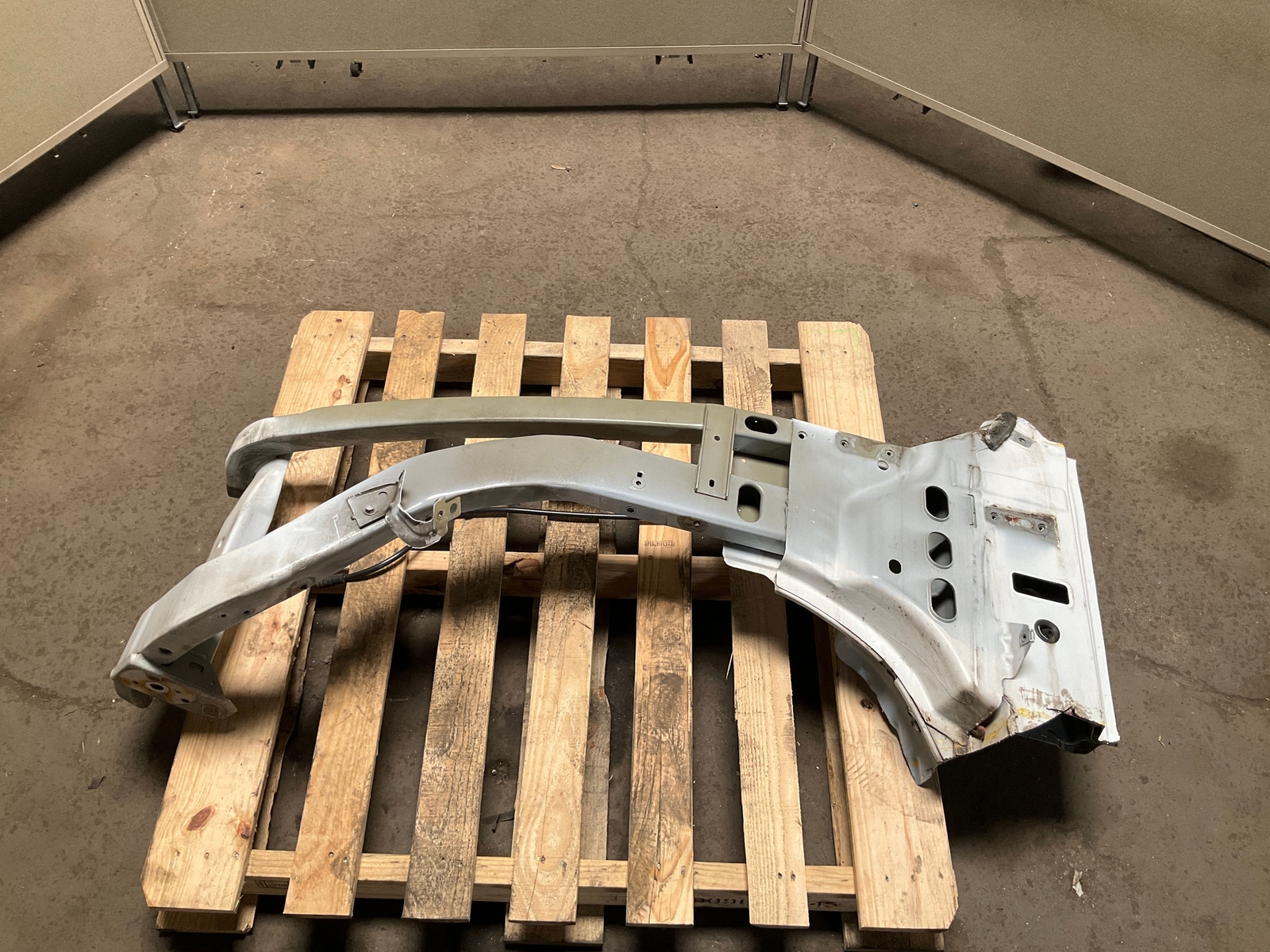 Silver 13-18 RAM 1500 front left driver frame apron radiator support with cutouts, mounted on wooden pallet.