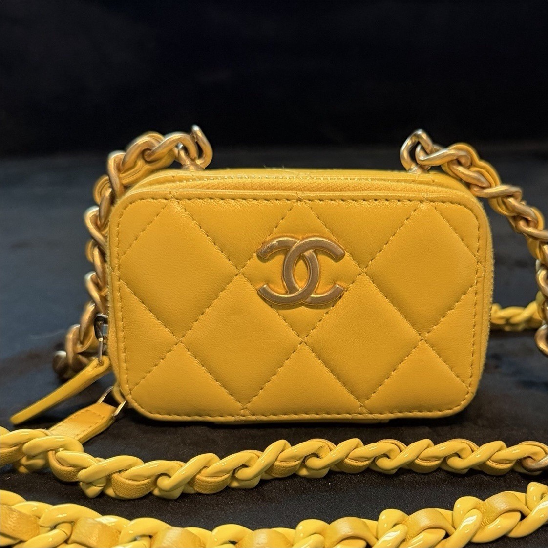 The item in the image is a CHANEL Mini Lacquered Chain Clutch in