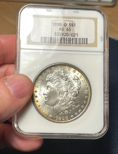 Morgan Dollar:  1898 O.  NGC MS 65.  Rim toning.  Frosty!   (see video!)