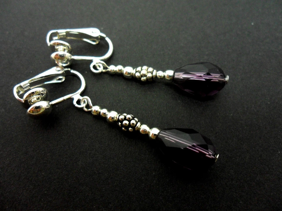 A PAIR OF DANGLY PURPLE GLASS CRYSTAL TEARDROP CLIP ON EARRINGS. NEW. - Image 1 of 1