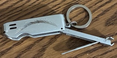 Unique vintage silver toned etched cigarette lighter with attached nail clipper