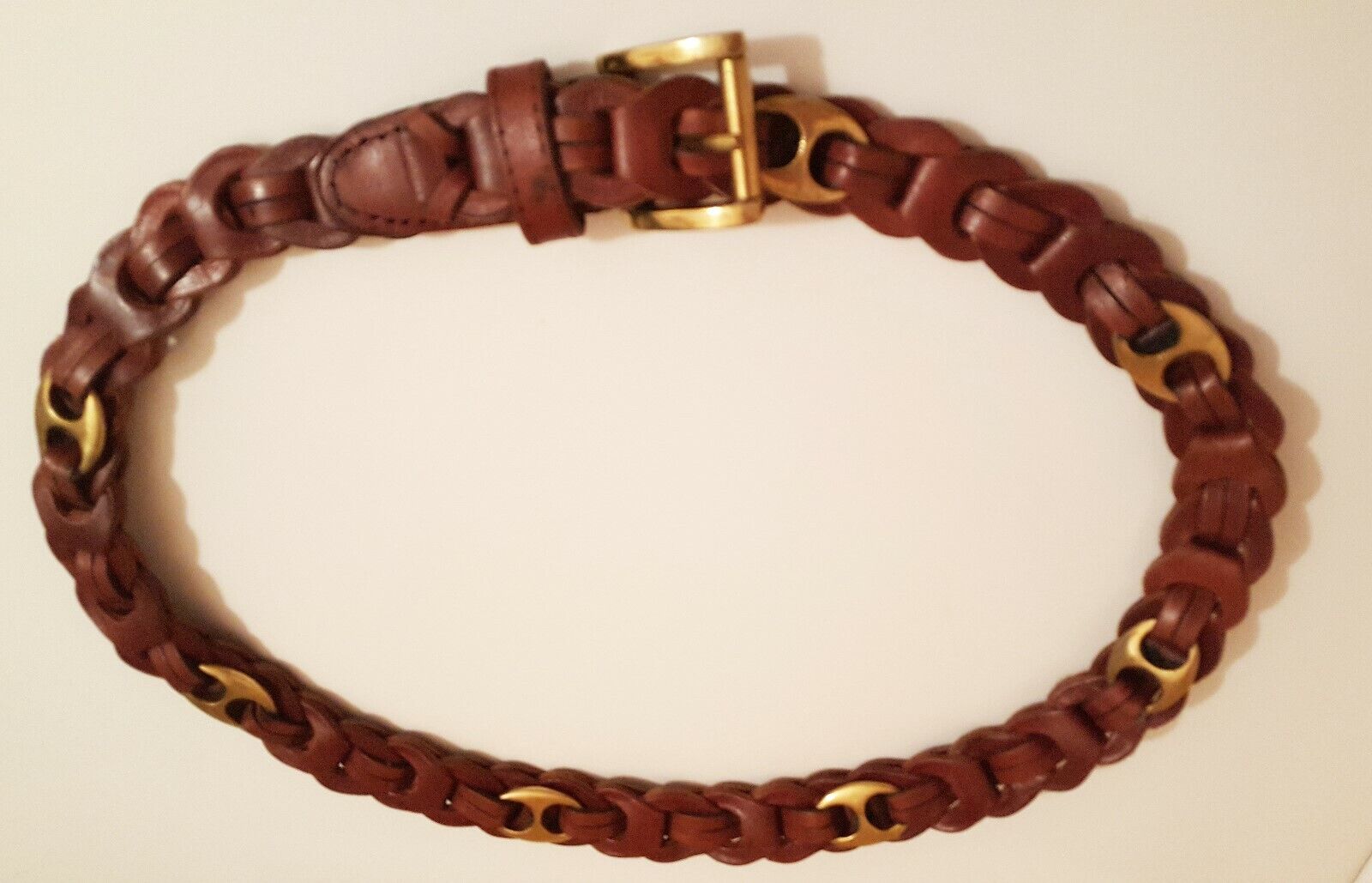 GLORIA VANDERBIL BELT-STAMPED IN LEATHER INTERTWINED WITH 7 OVAL BRASS LINKS $10