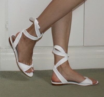 white flat sandals with ankle strap