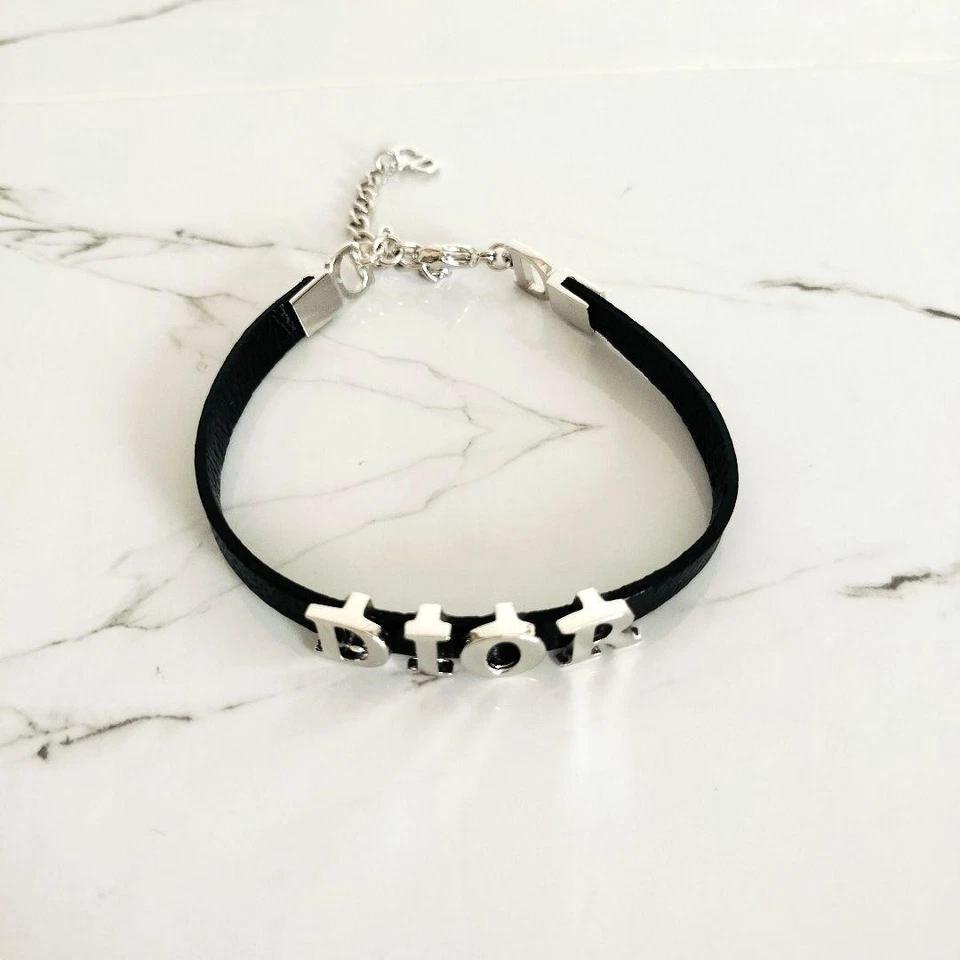 Pulsera Christian Dior en cuero negro con logo placa color plata usada en caja Foto 2 de 4