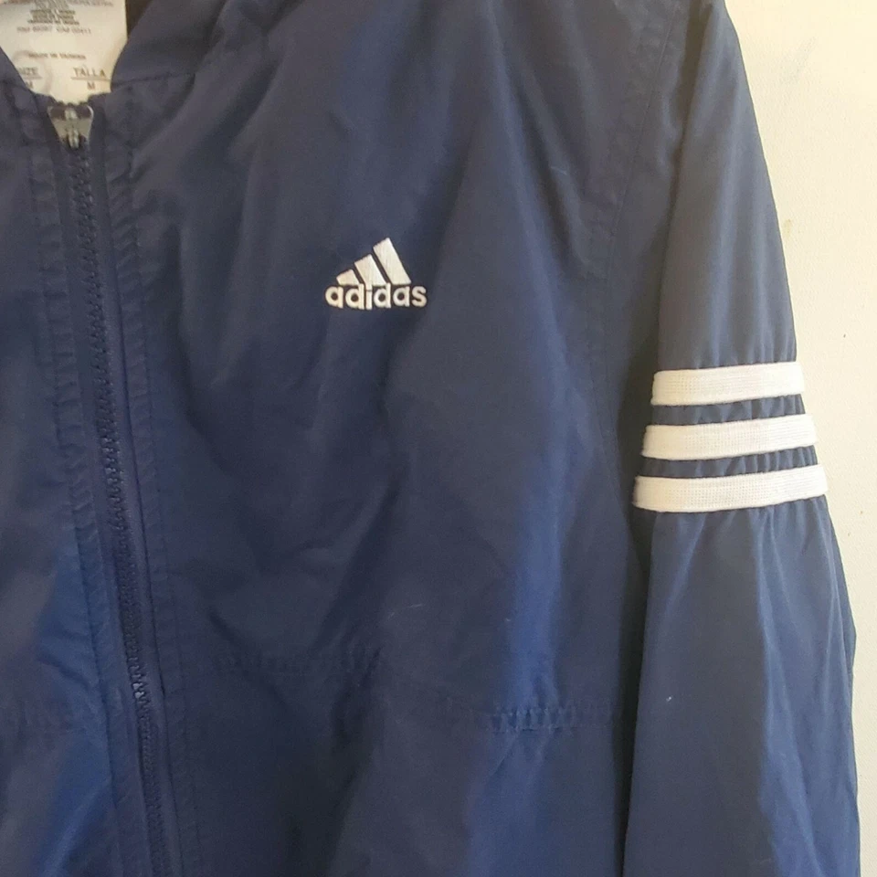 Chaqueta cortavientos Adidas para niñas talla M con capucha cremallera bolsillos ligeros azul blanco Foto 3 de 4