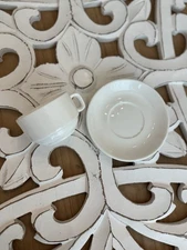 Set of four white ceramic espresso cups with matching saucers