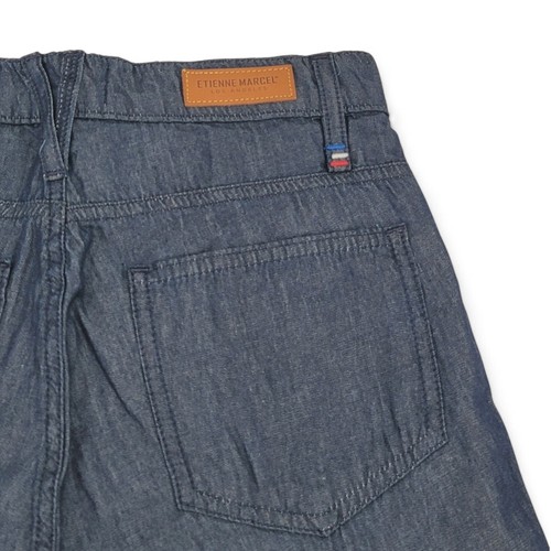 Blue Etienne Marcel skinny crop jeans with back pocket, brown leather patch on waistband, and red, white, and blue flag on hem.