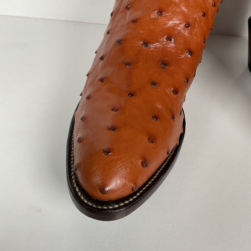 Brown ostrich quill women's cowboy boots with pointed toes and dark brown soles, featuring textured leather uppers.