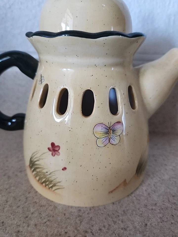 Tetera a la sombra de velas con pájaros azules y flores de interiores de casas en Texas Foto 2 de 4