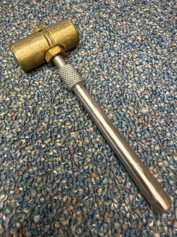 A hand-crafted machinist's hammer in solid brass — the kind of satisfying, weighty tool that belongs on a workshop shelf or a desk as a conversation piece.