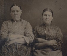PORTRAIT OF SMIRKING PORTLY WOMEN SEATED W/ CROSSED ARMS