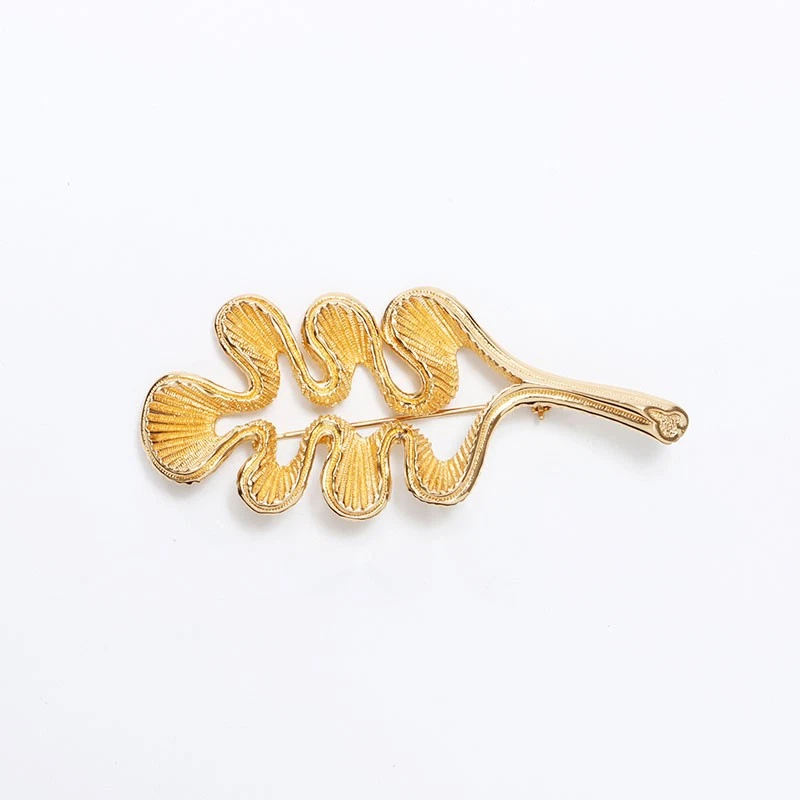 Broche Christian Dior feuille dorée neuve avec étiquette, accessoire bijou élégant