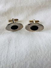 Vintage Swank cufflink featuring a black onyx inlay in a yellow gold-toned, Oval