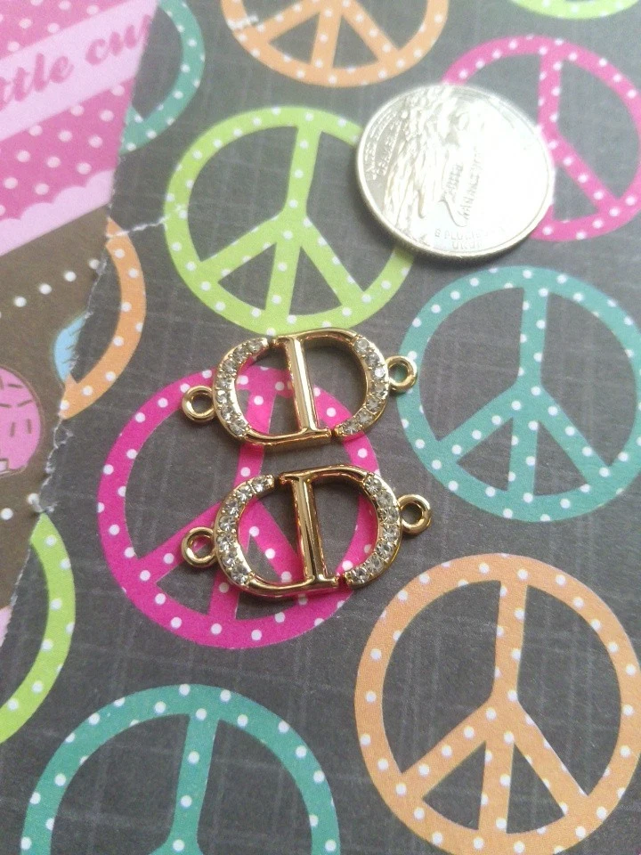 Lotto di 2 ciondoli Dior tono oro 27 mm con cerniera