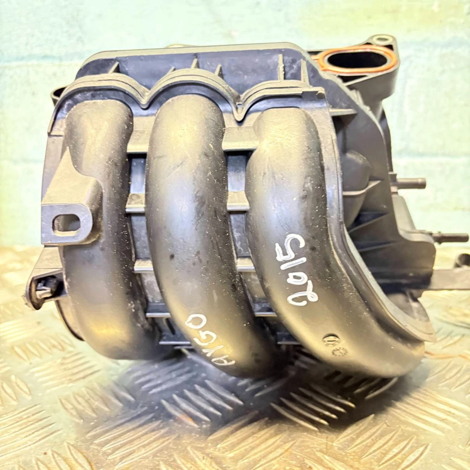 Actual black composite intake manifold runner view with stock marking