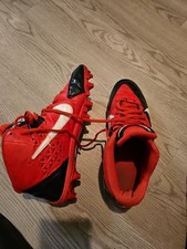 pair of red and black Nike cleats, likely for sports like football or soccer. 10