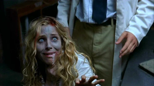 Hand reaches toward blonde woman in white shirt, pants, with red marks on face, text “BEYOND RE-ANIMATOR” at bottom.