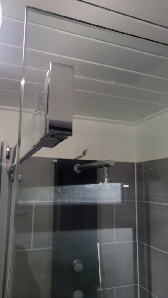 GLASS SHOWER ENCLOSURE WITH SLIDING DOOR AND CHROME TRIM AND PROFILES
