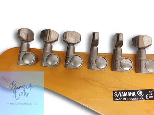 Six silver YAMAHA electric guitar tuning pegs with worn brass and silver finishes on a light wood fretboard.