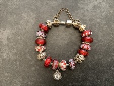 RED AND SILVER GLASS BEAD AND SILVER CHARM BRACELET. BOXED