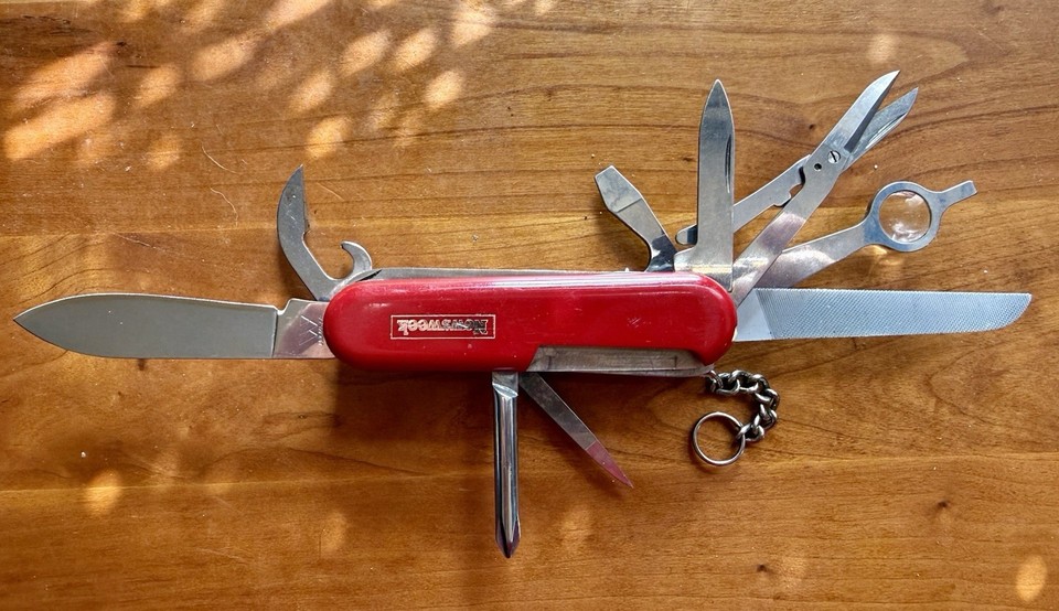 A vintage Wenger Swiss Army Knife with the rare magnifier and scissors combo — Wenger was absorbed by Victorinox in 2013, making originals genuine collectibles.