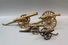Set of four brass cannon desk ornaments, toys - two large, two smaller ones