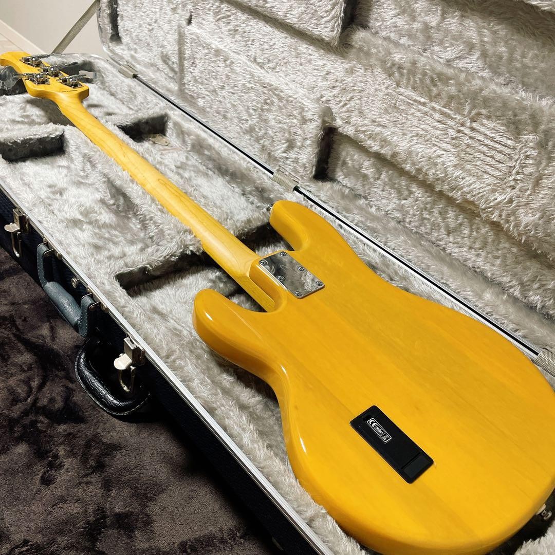 Sterling by MUSICMAN Ray 24 CA electric bass guitar with gold finish, black SC pickup, and silver hardware in padded hard case.