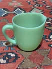 Vintage Fire King Jadeite milk pitcher with a pouring spout and handle