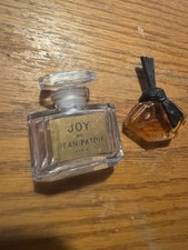 Dos botellas de perfume pequeñas, Joy And L’insolent The Joy Is Vacy, una tiene perfume