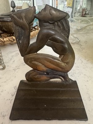 1940s striking metal bookend depicting a kneeling figure in the Aquarius motif.