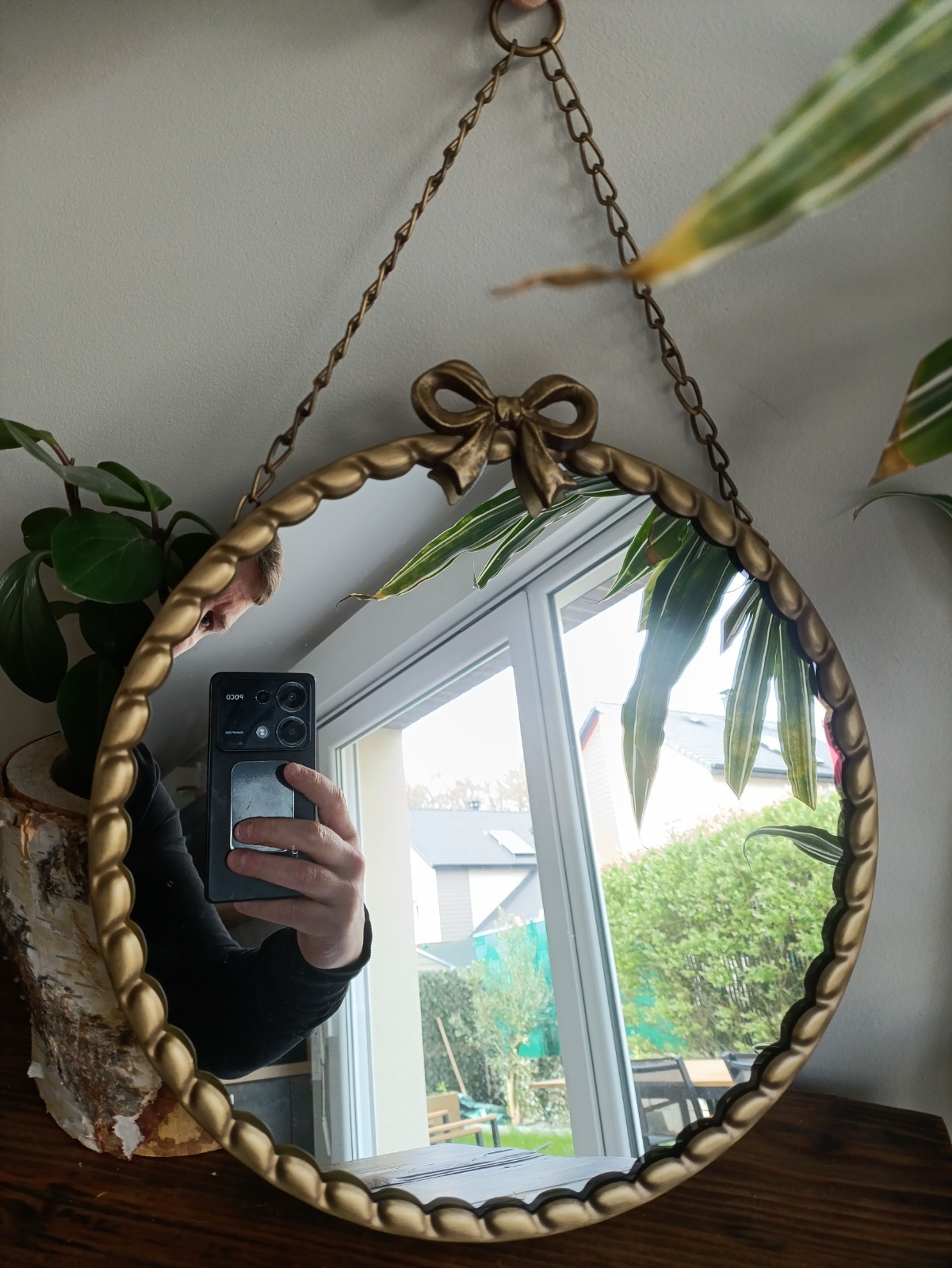 Miroir rond soleil en fer doré pour illuminer un mur sombre de salon