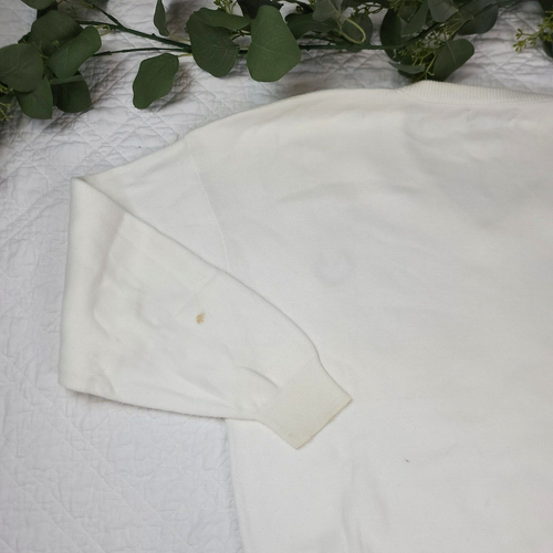 White VTG Christian Dior men’s V-neck sweater with long sleeves, beige cuffs, and a yellow spot on the left sleeve.