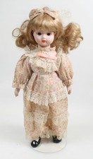 PORCELAIN DOLL W/ STAND, 16in TALL IN FLORAL DRESS AND BOW IN HAIR 