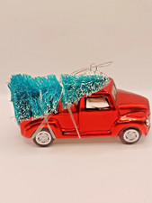 Ornament Featuring a Red Truck carrying a Christmas Tree