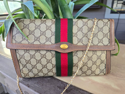 vintage Gucci GG Supreme canvas clutch features the iconic red and green Sherry