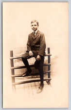 Postcard RPPC Young Man it Checkered Suit Sitting on Fence Real Photo