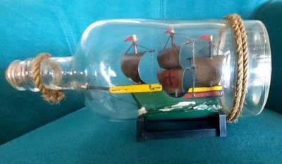 Schiffsmodell Segelboot auf dem Meer in Glasflasche mit Holzständer