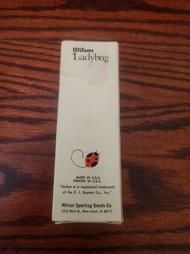 White rectangular Wilson Ladybug box with red and black ladybug graphic, labeled “Made in U.S.A.” on wooden surface.