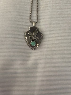 Sterling silver arrowhead pendant With flying eagle design and turquoise stone.