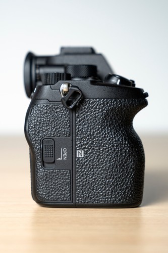 Black Sony Alpha a7S III body with textured grip, open lens cover, and visible “OPEN” and “Z” labels.
