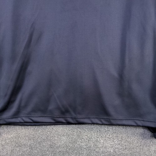 Close-up of dark blue fabric, 2XL size, with smooth surface and subtle textured hem, laid flat on gray carpet.